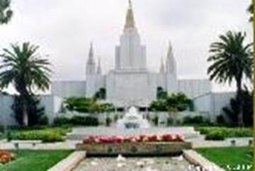 A white building with a fountain and trees

Description automatically generated